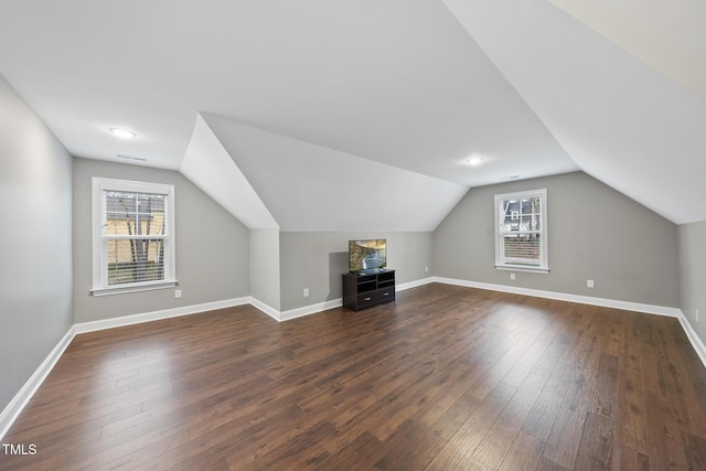 bonus room with dark wood-style floors, baseboards, and a wealth of natural light