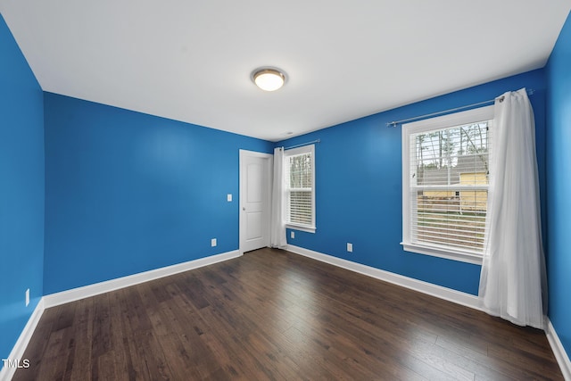 unfurnished room with dark wood-style floors and baseboards