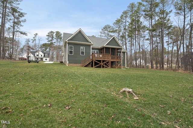 rear view of property featuring a deck, stairway, a yard, and a shingled roof