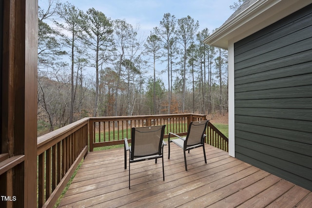 wooden terrace featuring a wooded view