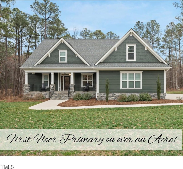 craftsman-style home with a porch, a shingled roof, and a front yard