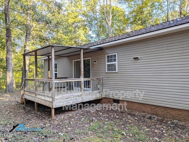 rear view of house featuring a wooden deck