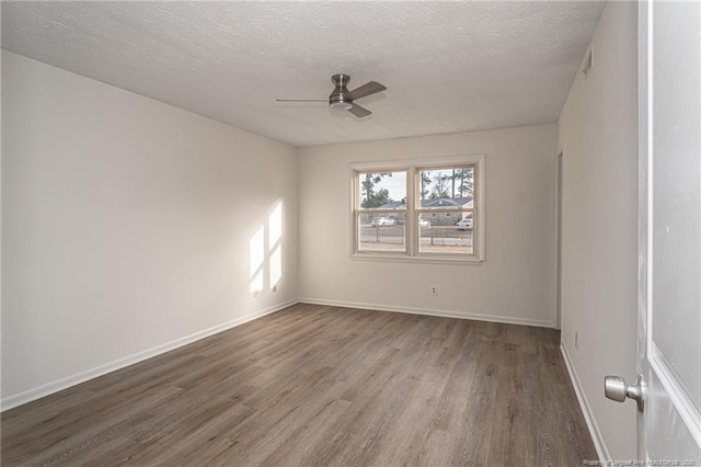 unfurnished room featuring a textured ceiling, wood finished floors, a ceiling fan, and baseboards