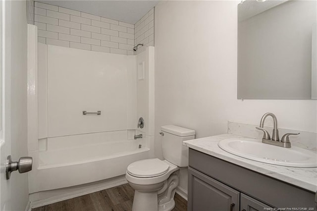 bathroom with toilet, vanity, wood finished floors, and shower / bathing tub combination