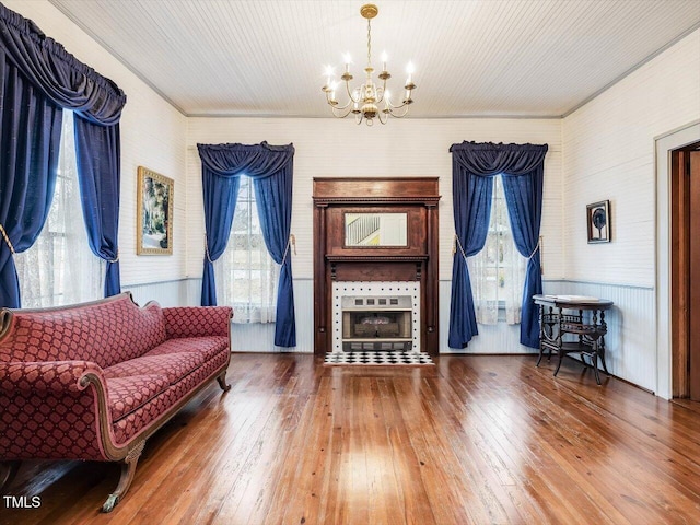 sitting room with plenty of natural light, wood-type flooring, and an inviting chandelier