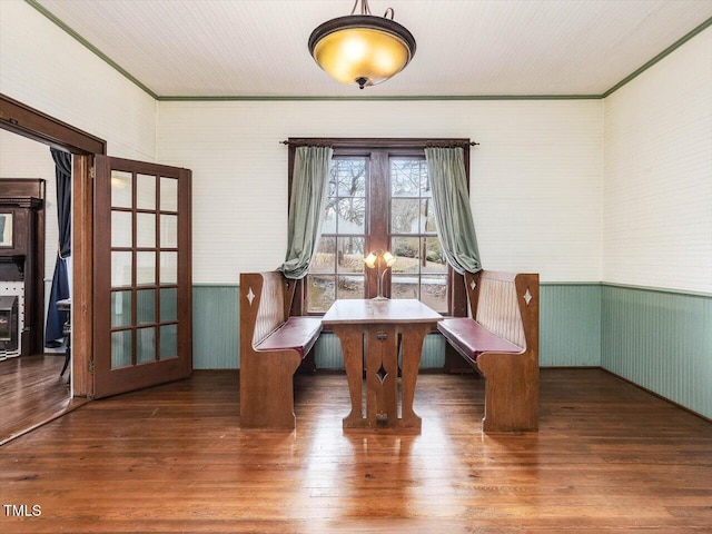 unfurnished room featuring ornamental molding, french doors, wainscoting, and dark wood finished floors