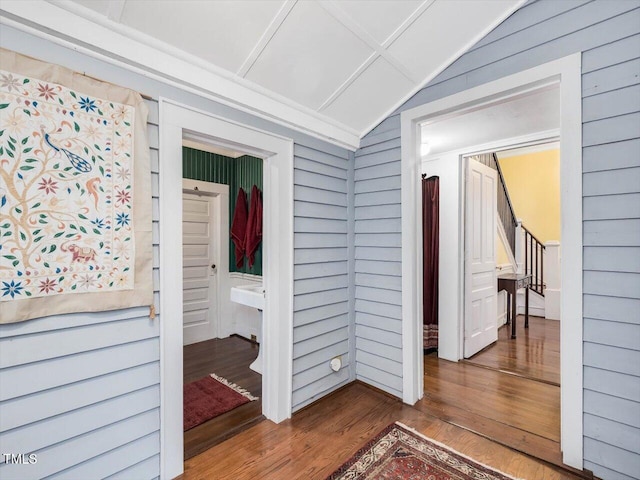 hallway with lofted ceiling and dark wood finished floors