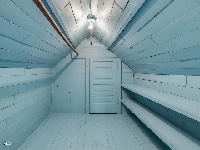 additional living space with wood walls, wood ceiling, vaulted ceiling, and light wood finished floors