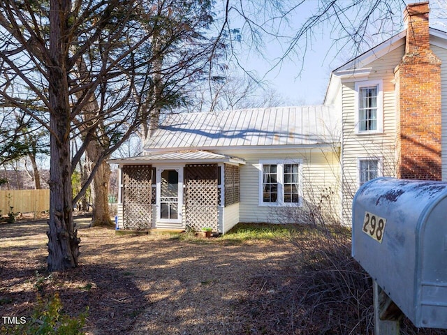 view of front of property with fence and metal roof