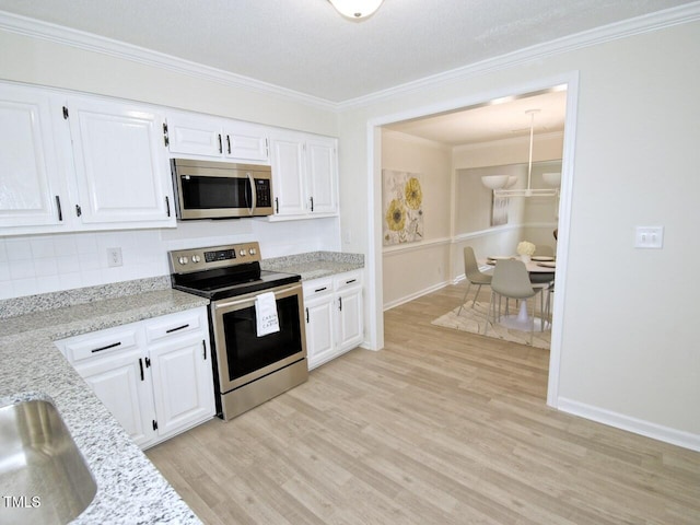 kitchen with white cabinetry, appliances with stainless steel finishes, light wood-style flooring, and ornamental molding