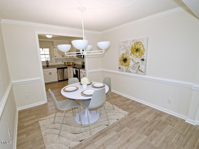 dining area with wood finished floors, baseboards, and ornamental molding