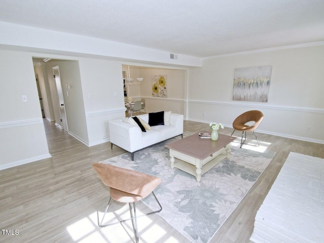 living area with visible vents, baseboards, and wood finished floors