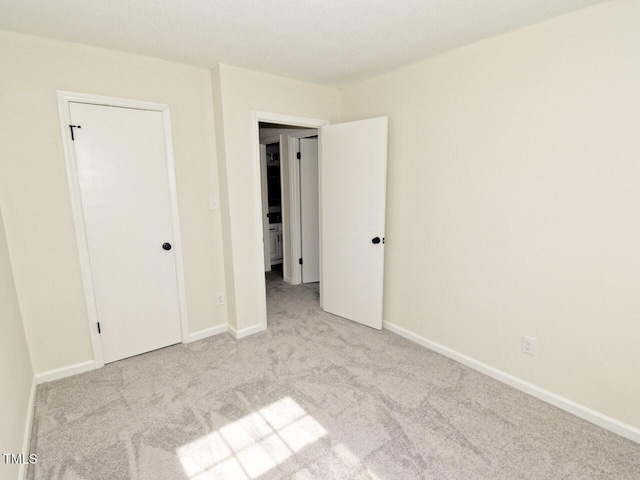 unfurnished bedroom featuring carpet flooring and baseboards