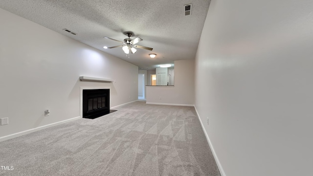 unfurnished living room featuring light carpet, a fireplace, visible vents, and a ceiling fan