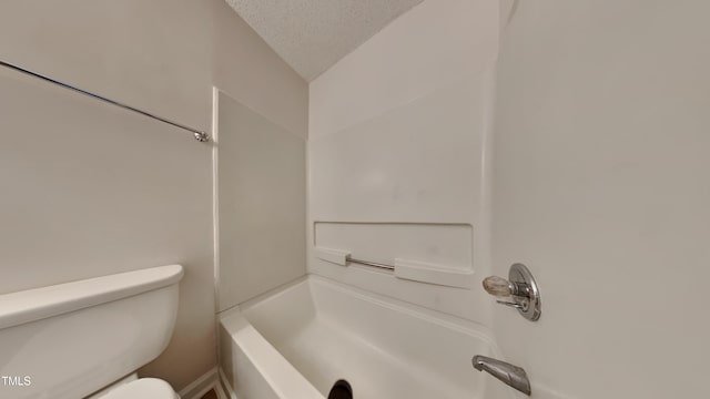 full bathroom featuring a textured ceiling, toilet, and washtub / shower combination