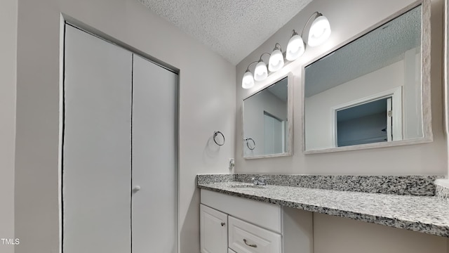 bathroom featuring a textured ceiling and vanity