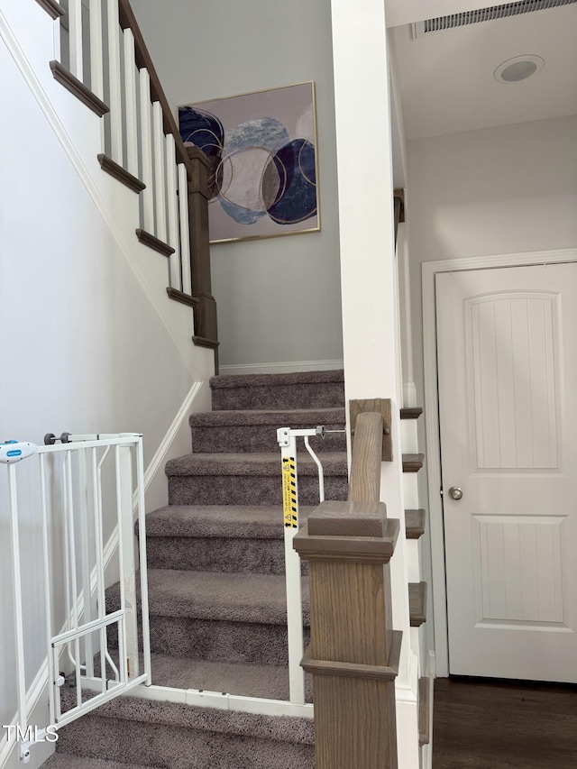 stairway with baseboards and wood finished floors