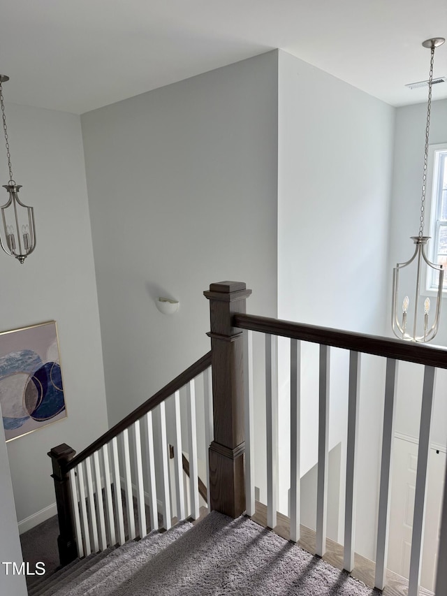 stairway featuring carpet, visible vents, and a notable chandelier