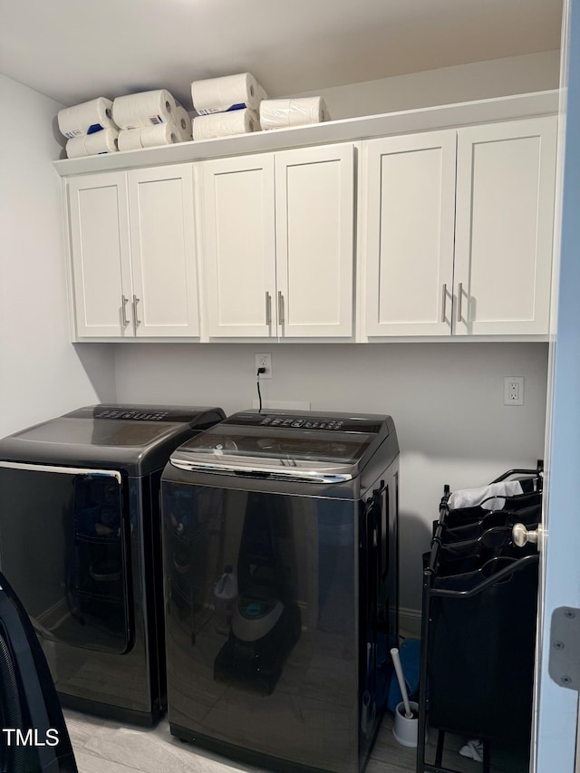 washroom with cabinet space and separate washer and dryer