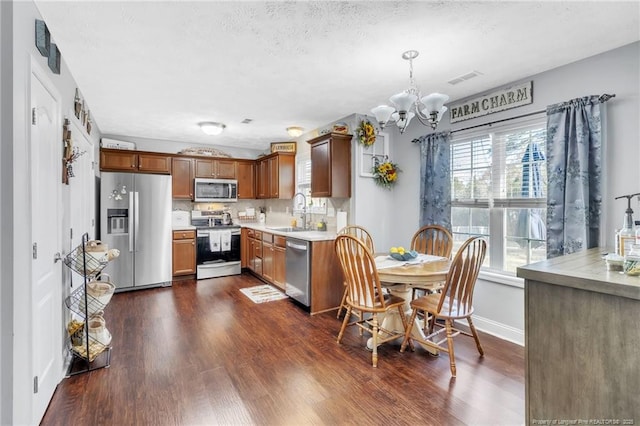 dining room with visible vents, dark wood-type flooring, a textured ceiling, an inviting chandelier, and baseboards