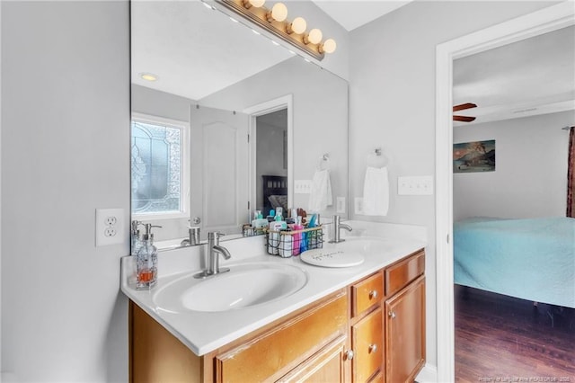 ensuite bathroom with double vanity, connected bathroom, and a sink