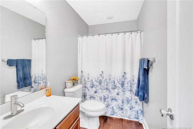 bathroom featuring vanity, curtained shower, toilet, and wood finished floors