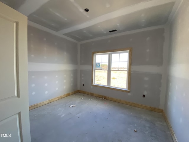 unfurnished room featuring concrete flooring, visible vents, and baseboards