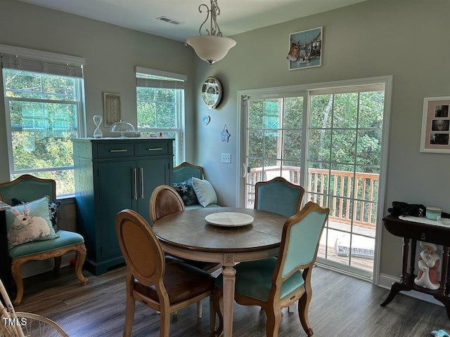 dining area featuring baseboards, visible vents, and wood finished floors