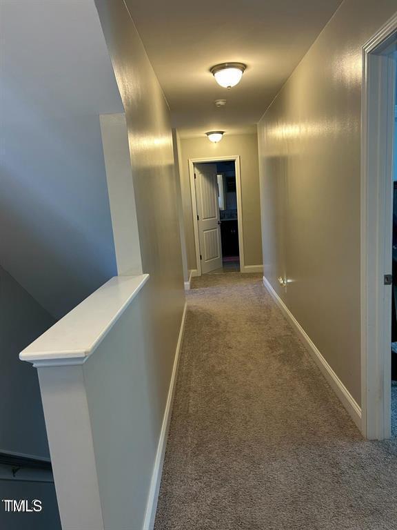 hall with carpet floors and baseboards