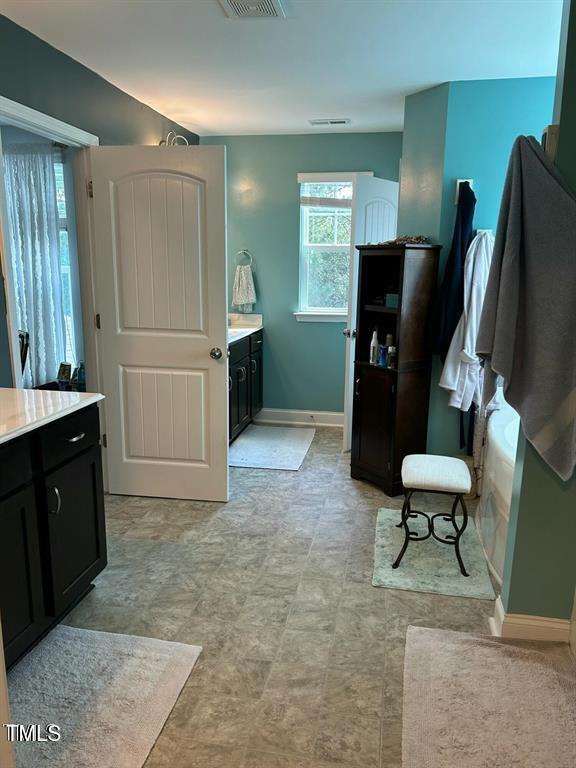 bathroom with baseboards, visible vents, and vanity