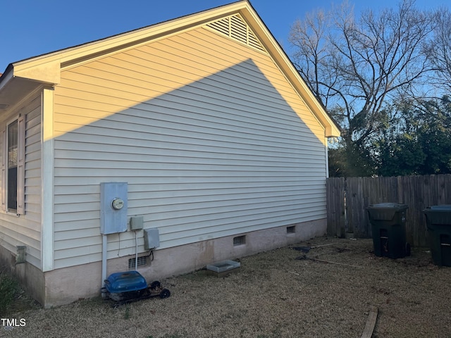 view of side of property featuring crawl space and fence