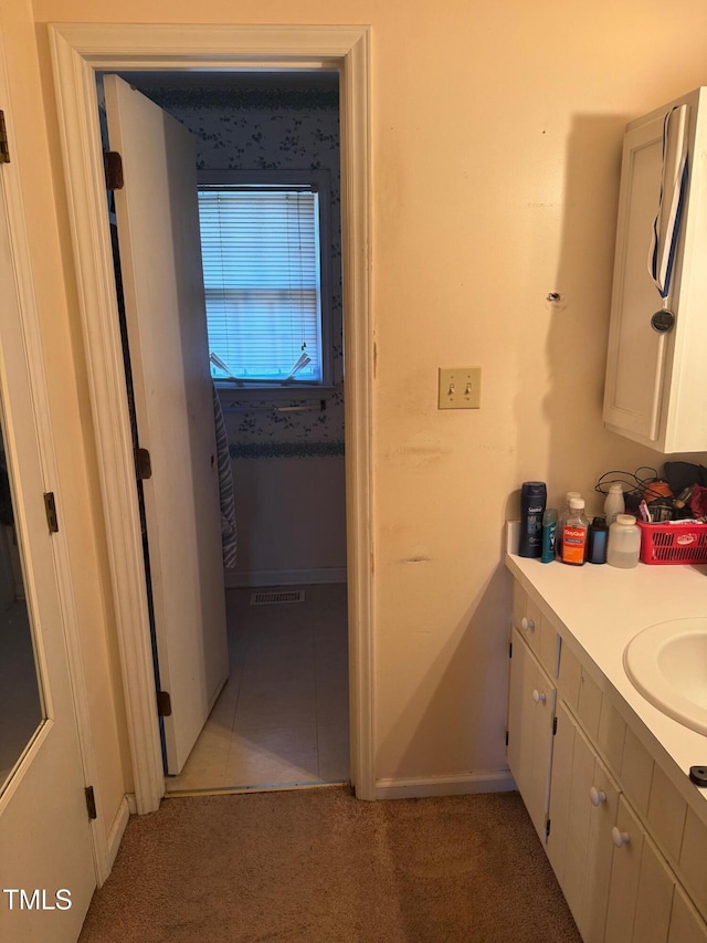 bathroom with tile patterned flooring, baseboards, and vanity