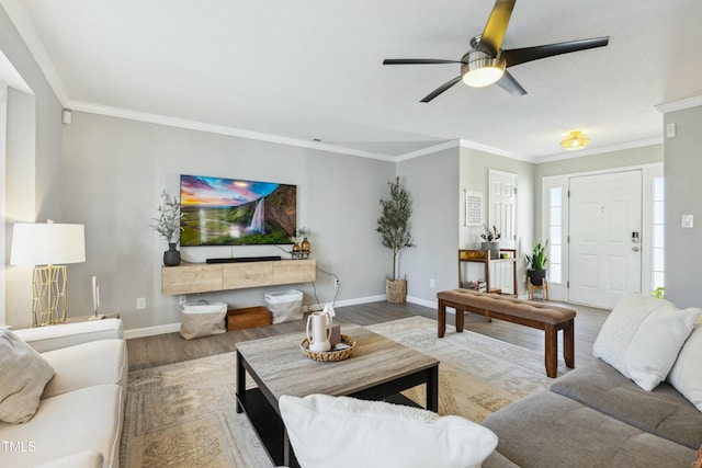 living area with ceiling fan, crown molding, baseboards, and wood finished floors