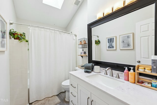 bathroom featuring toilet, a skylight, vanity, and visible vents