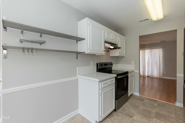 kitchen featuring open shelves, white cabinetry, stainless steel electric stove, and light countertops