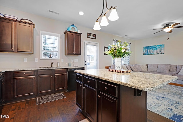 kitchen featuring black dishwasher, visible vents, dark wood-type flooring, and a sink