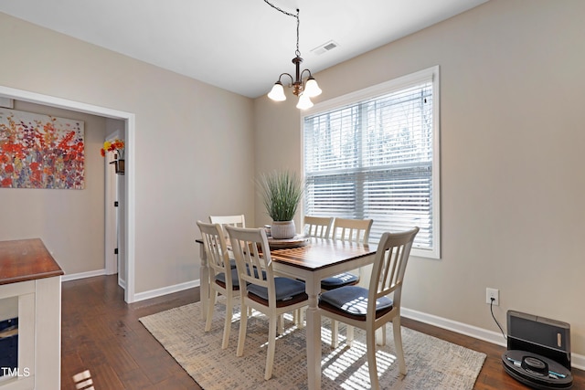 dining space featuring a chandelier, visible vents, dark wood finished floors, and baseboards