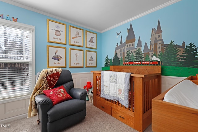 sitting room featuring carpet floors, ornamental molding, a decorative wall, and wainscoting