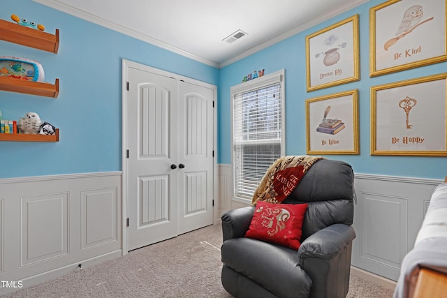 living area featuring carpet floors, a wainscoted wall, visible vents, and crown molding