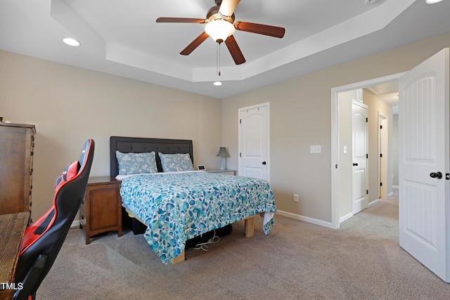 bedroom featuring baseboards, a ceiling fan, carpet, a tray ceiling, and recessed lighting