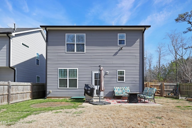 back of property with a patio area, a fenced backyard, and a lawn