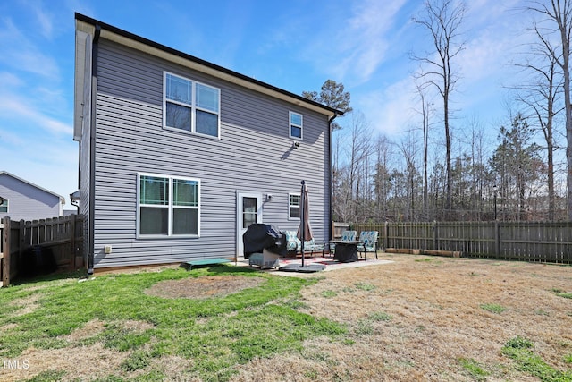 rear view of house with a patio area, a fenced backyard, and a lawn