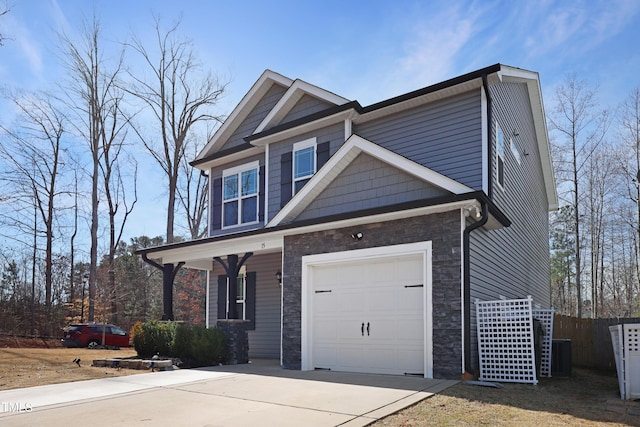 craftsman-style home with a garage, stone siding, and concrete driveway