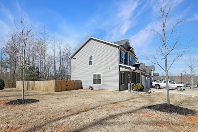 view of home's exterior featuring driveway and fence