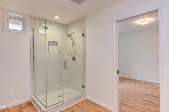 bathroom with a marble finish shower, visible vents, baseboards, wood finished floors, and recessed lighting