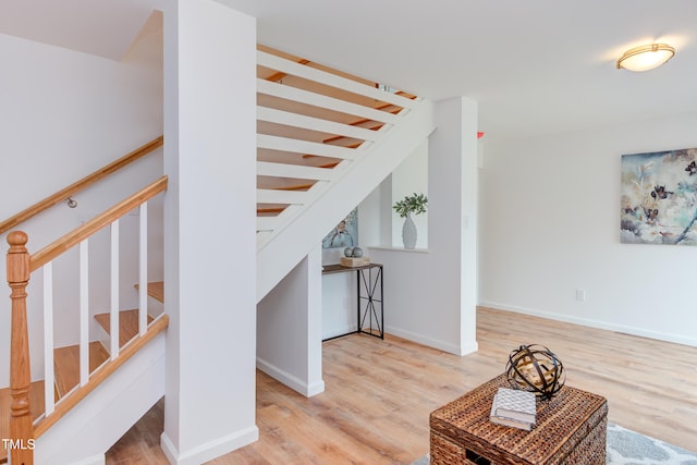 stairs with wood finished floors and baseboards