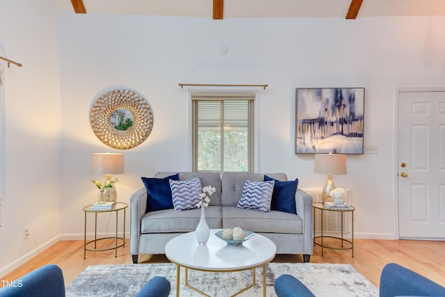 living area featuring beamed ceiling, wood finished floors, and baseboards