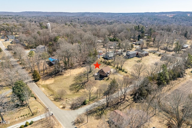 bird's eye view with a wooded view