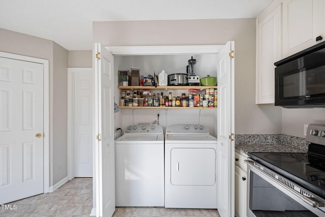 washroom featuring laundry area, separate washer and dryer, and baseboards