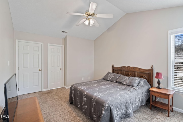 carpeted bedroom featuring ceiling fan, baseboards, visible vents, and vaulted ceiling